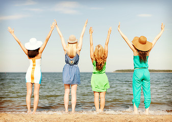 Image showing girls with hands up on the beach