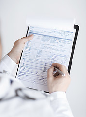 Image showing male doctor holding prescription paper in hand