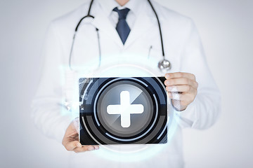 Image showing male doctor holding tablet pc with medical app