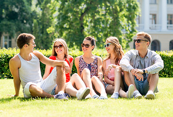 Image showing group of smiling friends outdoors sitting on grass