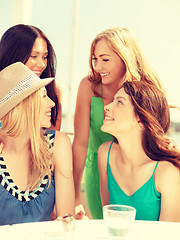 Image showing group of smiling girls in cafe on the beach