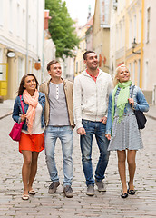 Image showing group of smiling friends walking in the city