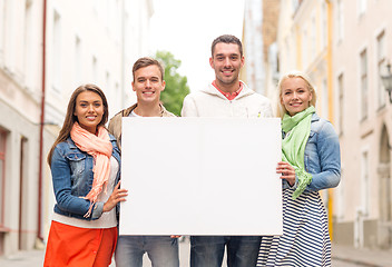 Image showing group of smiling friends with blank white board