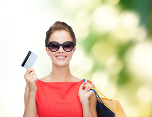 Image showing smiling woman with shopping bags and plastic card