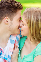 Image showing smiling couple kissing and hugging in park