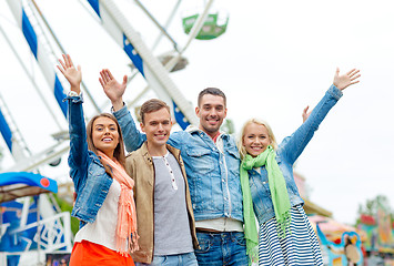 Image showing group of smiling friends waving hands