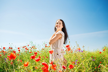 Image showing smiling young woman on poppy field