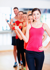 Image showing group of smiling people with dumbbells in the gym