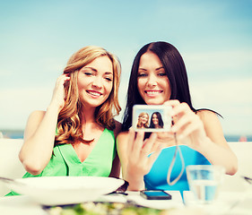 Image showing girls taking photo in cafe on the beach