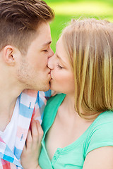 Image showing smiling couple kissing and hugging in park