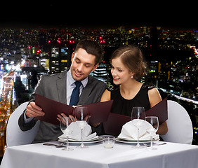 Image showing smiling couple with menus at restaurant