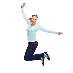 Image showing smiling young woman jumping in air