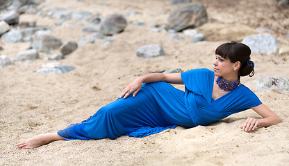 Image showing girl in a dress lying on the sand