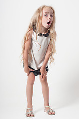 Image showing Little girl in white dress fooling around