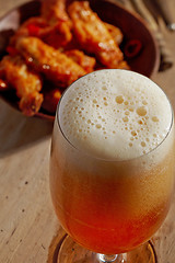 Image showing glass of fresh beer and fried chicken wings