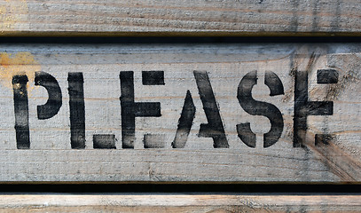 Image showing PLEASE stencilled in capitals on wood