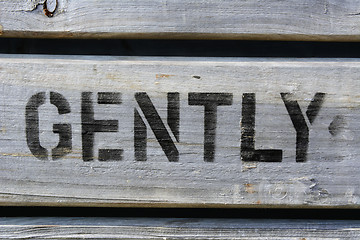 Image showing GENTLY stencilled in capitals on wood