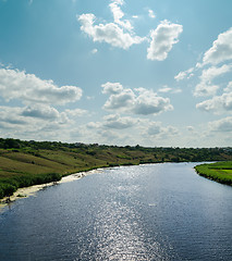 Image showing light clouds in blue sky over river with reflections