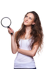 Image showing Smiling woman with magnifying glass looking up