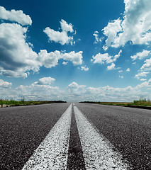 Image showing two white lines on black road and dramatic sky with clouds over 