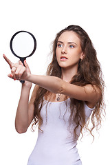 Image showing Surprised woman looking through magnifying glass