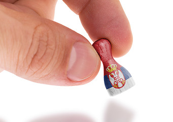 Image showing Hand holding wooden pawn, flag painting, selective focus