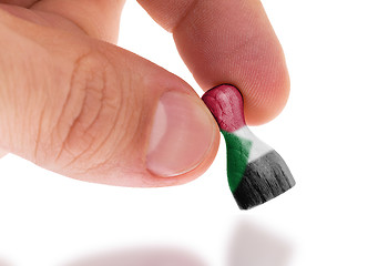 Image showing Hand holding wooden pawn, flag painting, selective focus