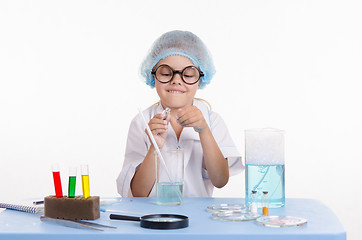 Image showing Child chemist opens the flask with reagent