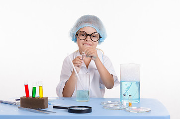 Image showing Girl Chemist opens flask with reagent