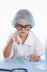 Image showing Girl chemist pours reagent into the flask with liquid