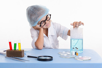 Image showing Chemist girl stuck a finger in soapy water