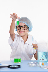 Image showing Scientist girl happily looking at test tube with liquid