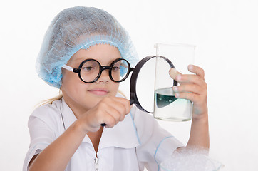 Image showing Chemist enthusiasm considering flask under a magnifying glass