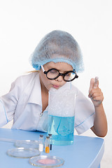 Image showing Girl blows foam chemist flask with liquid