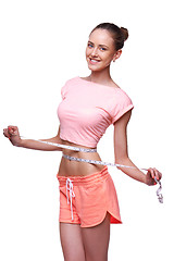 Image showing Woman measuring her waist with a measuring tape