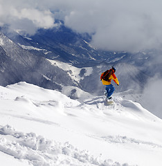 Image showing Snowboarder on off-piste slope an mountains in haze