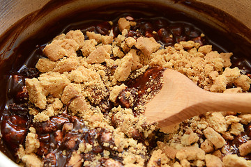 Image showing Stirring crushed biscuits into melted chocolate