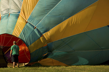 Image showing Man inflating a hot-air balloon with a burner