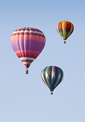 Image showing Three Hot-Air Balloons Floating against a Blue Sky