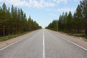 Image showing Long road stretching out into the distance under a blue sky 