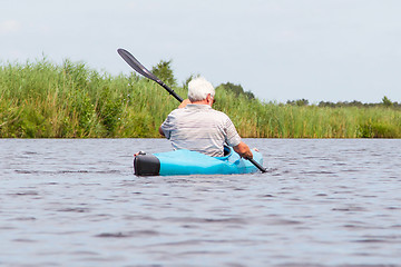 Image showing Man paddling in a blue kayak