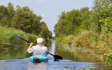 Image showing Man paddling in a blue kayak