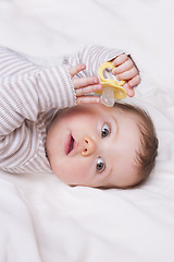 Image showing Baby girl lies down on a white blanket