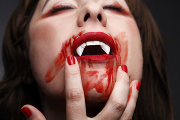 Image showing  Female vampire licking blood 