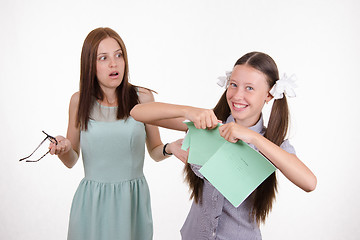 Image showing Schoolgirl got a bad grade and tear notebook