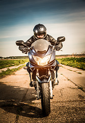 Image showing Biker racing on the road