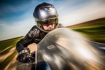 Image showing Biker racing on the road