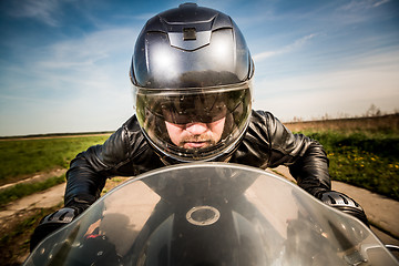 Image showing Biker racing on the road