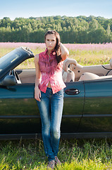 Image showing Young woman standing near car