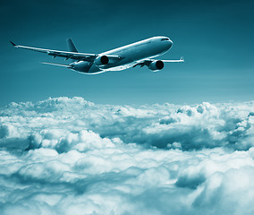 Image showing Passenger plane flies over cumulus clouds